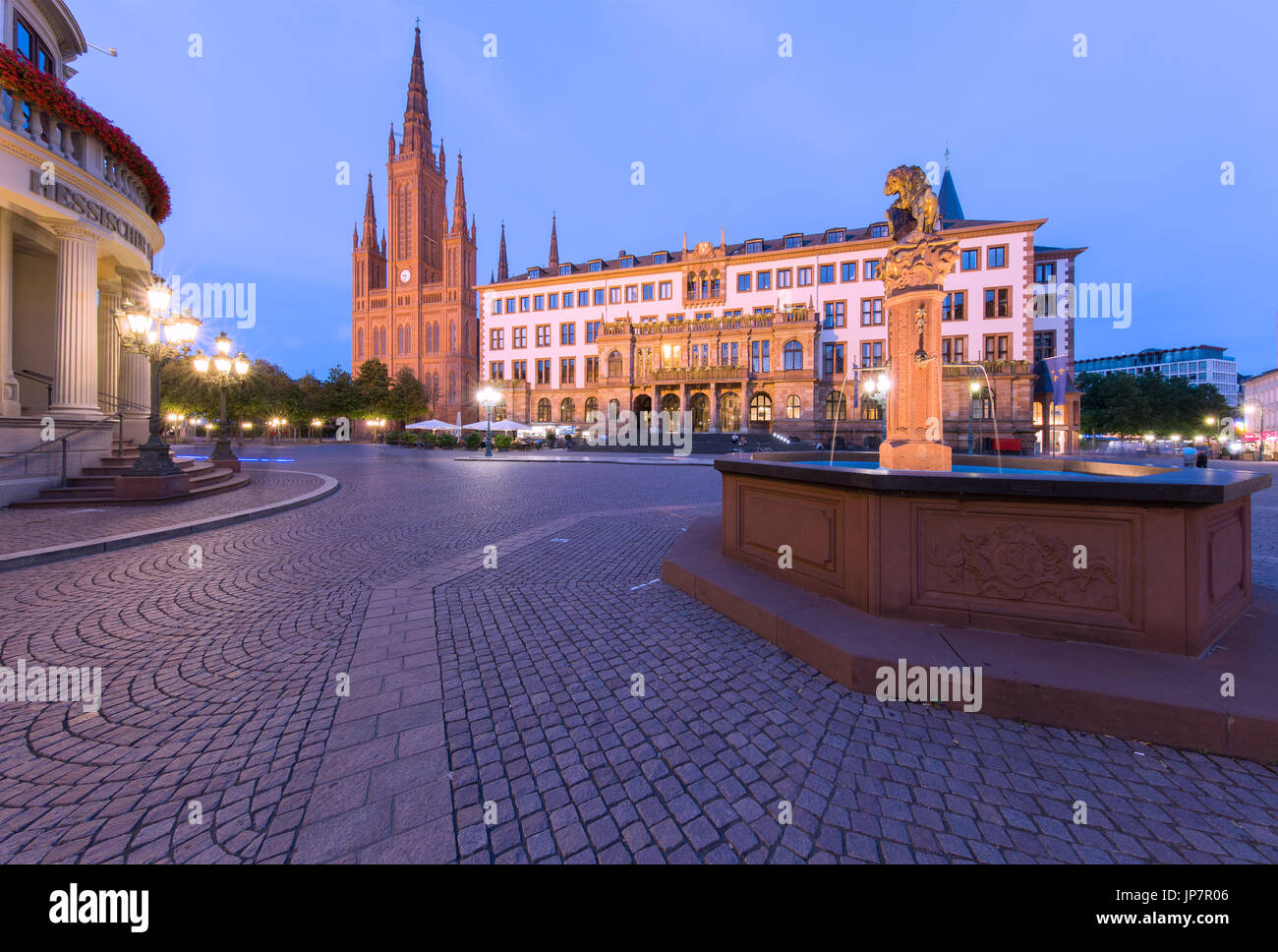 Il Schloßplatz (Piazza del Castello) in Wiesbaden come il sole tramonta con Marktkirche e Municipio in background Foto Stock