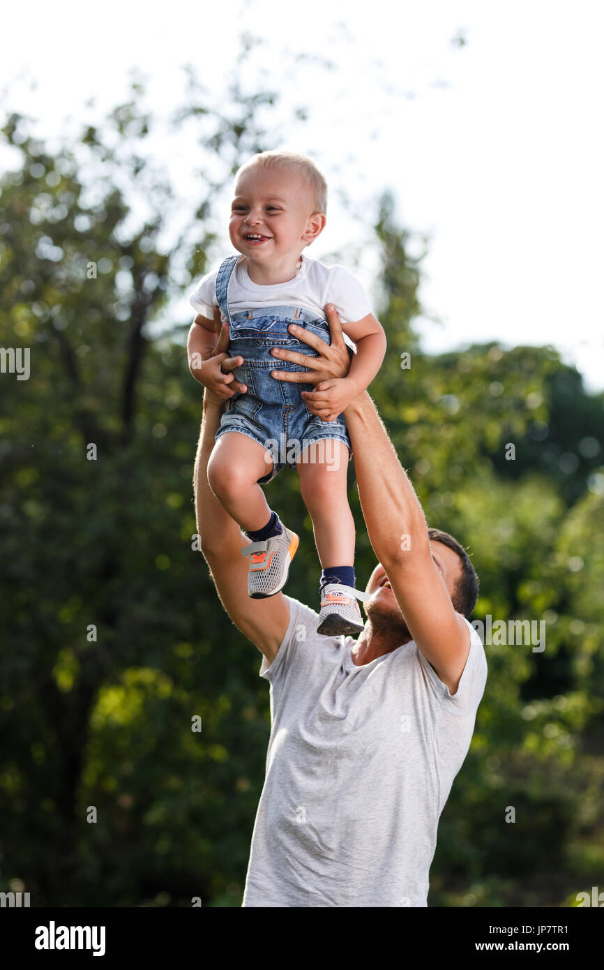 Momenti felici. Il Padre genera il figlio in cielo al tramonto in natura. Foto Stock