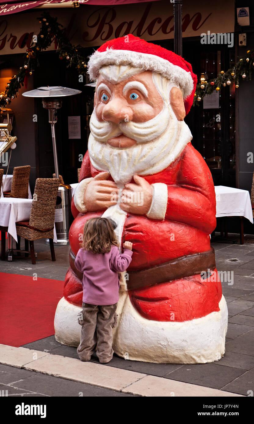 Bambina abbracciando Santa Claus in Nizza Francia Foto Stock