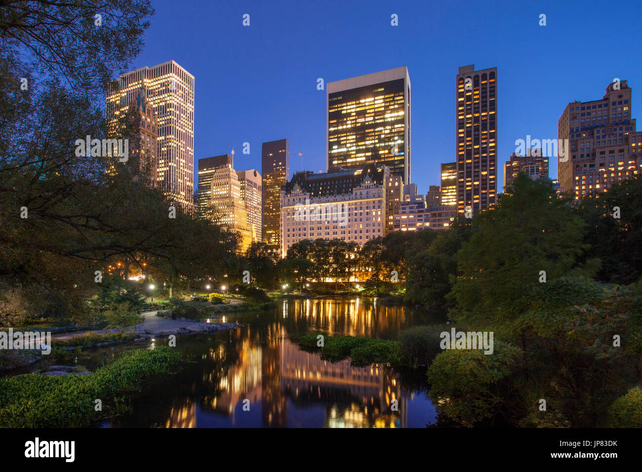 Central Park al crepuscolo con riflessioni di Midtown Manhattan edifici, New York City USA Foto Stock