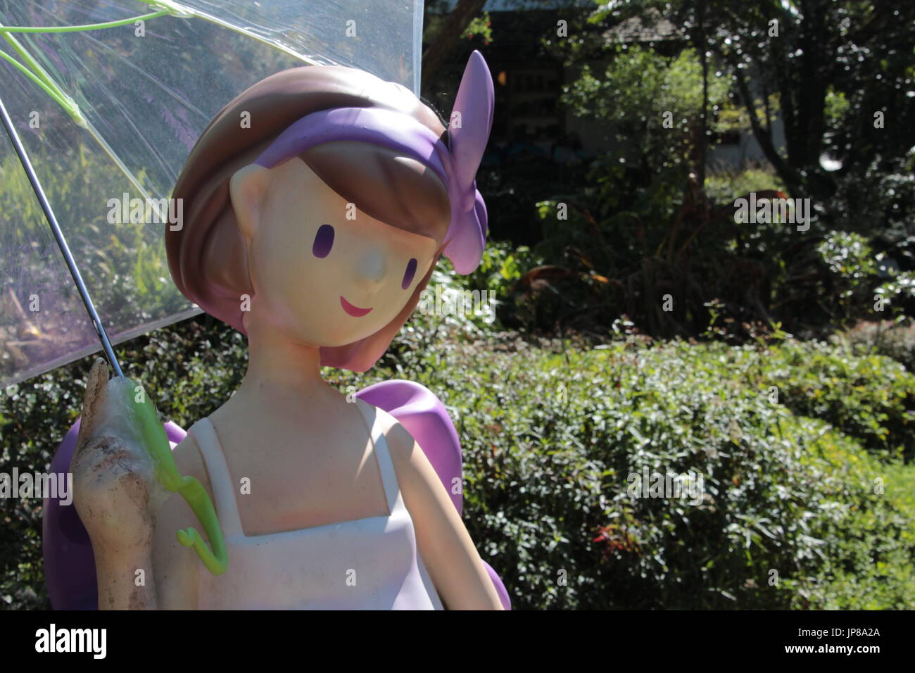Ragazza bambola holding ombrello trasparente in posa per gli scatti Foto Stock