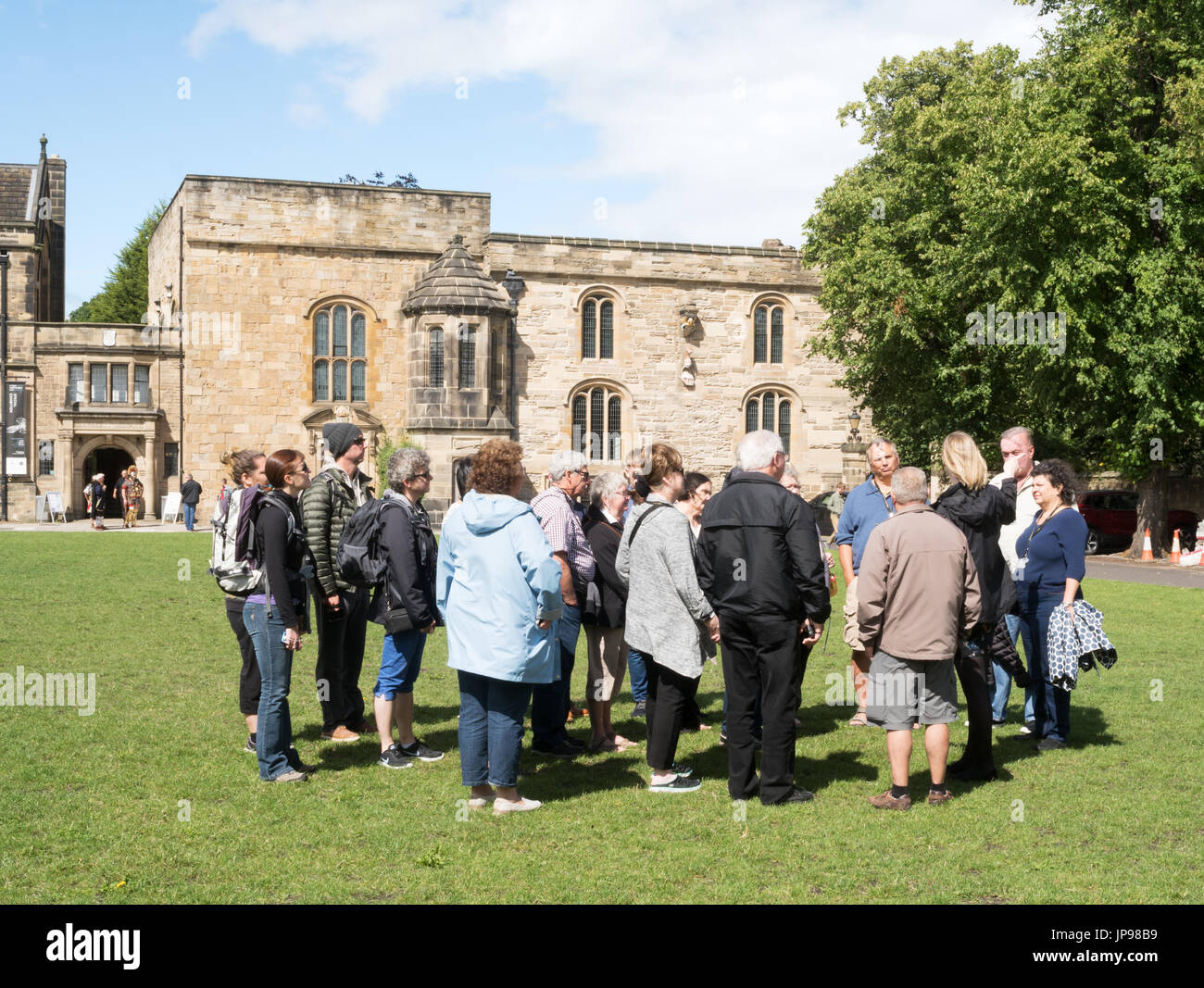 Una guida turistica e il gruppo di visitatori al di fuori dell Università di Durham libreria sul palazzo verde, Durham, England, Regno Unito Foto Stock