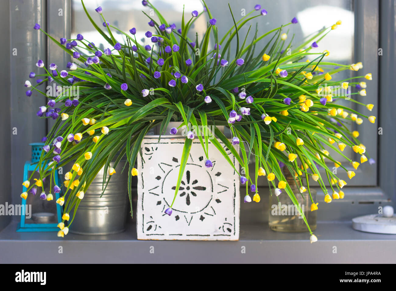 Decorativi fiori artificiali sul davanzale della finestra Foto