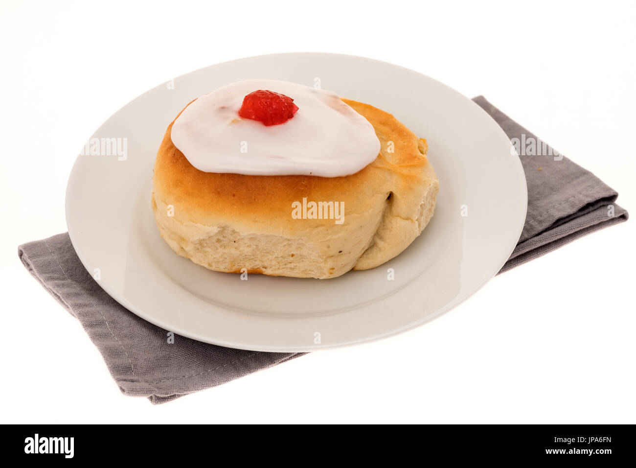 Un bun ghiacciata la torta su un piatto bianco - sfondo bianco Foto Stock