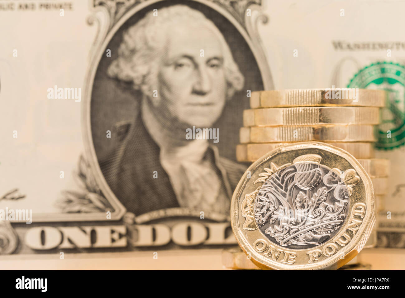 Immagine concettuale di una moneta britannica a un dollaro con una banconota leggermente fuori fuoco sullo sfondo. Foto Stock