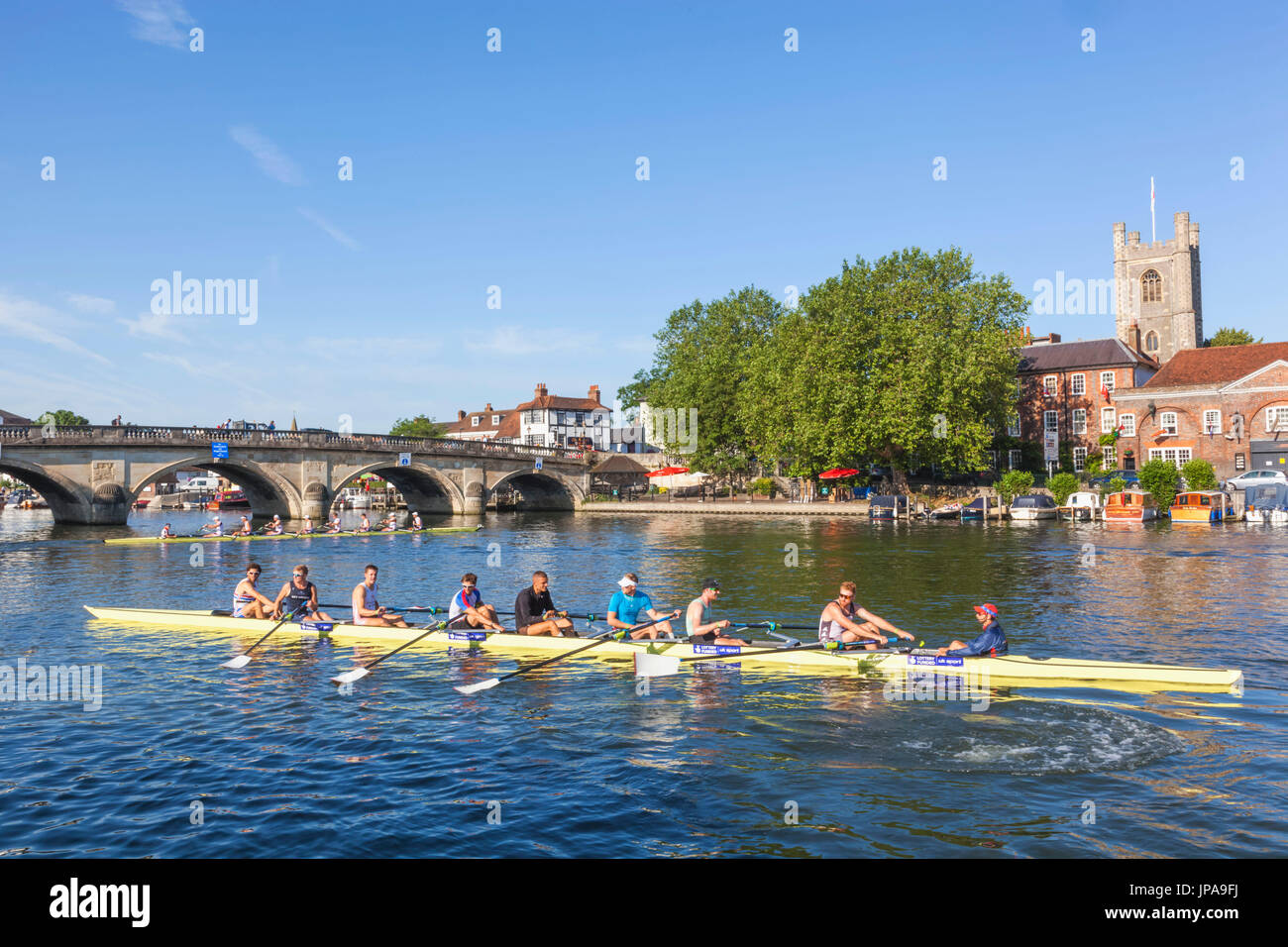 Inghilterra, Oxfordshire, Henley-on-Thames, lo skyline della città e vogatori sul Fiume Tamigi Foto Stock