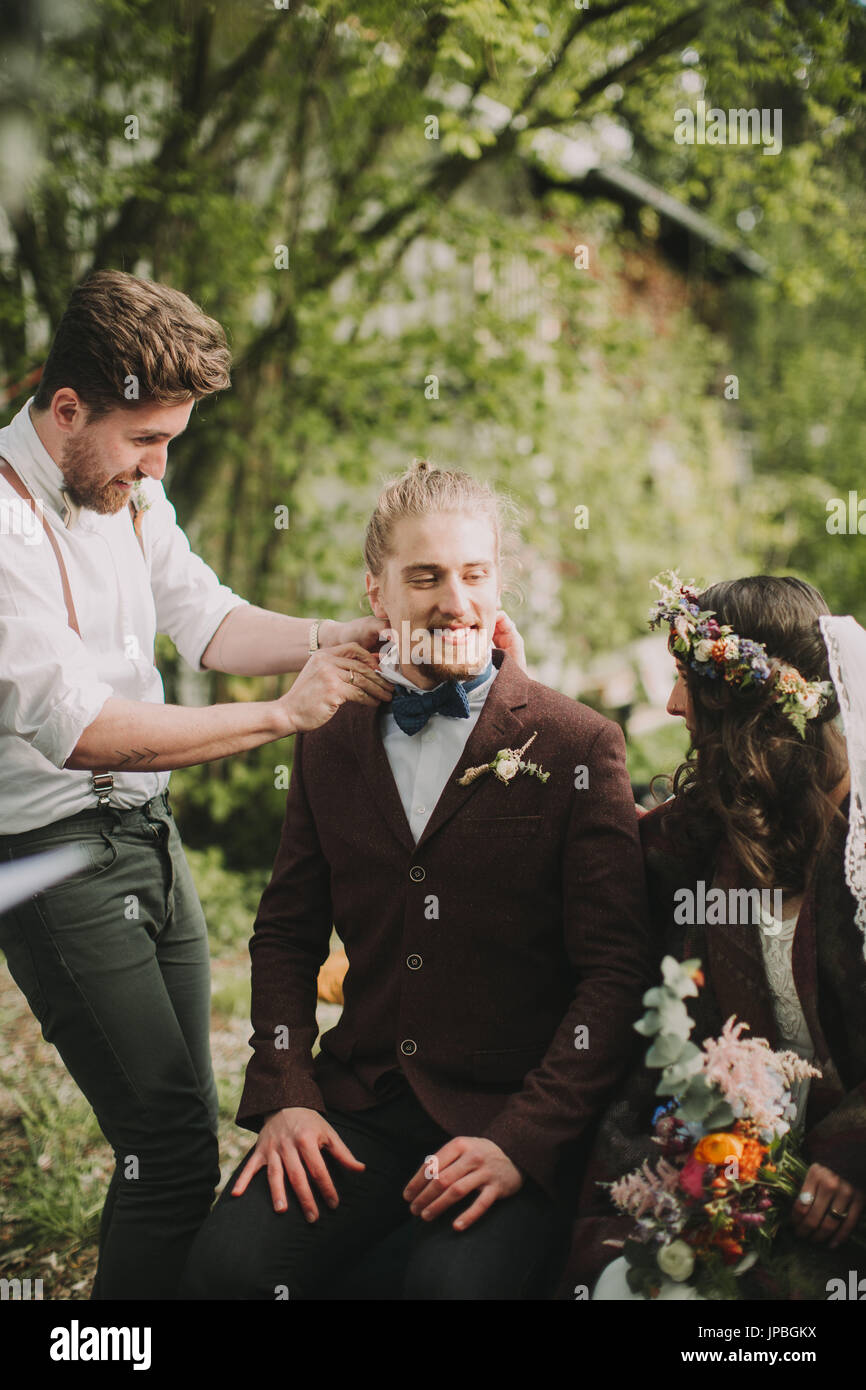 Si alternano sposi alla cerimonia di matrimonio all'aperto, testimone cravatte sposo il filtro bow tie, emozione, nervosismo Foto Stock