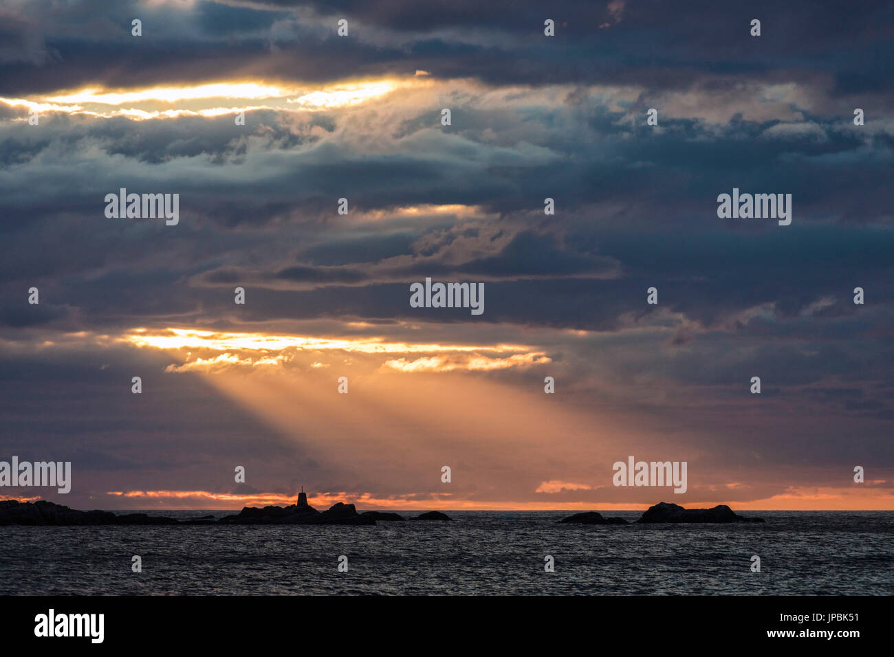 Raggi del sole di mezzanotte accende il faro affacciato sul mare Eggum Vestvagøy Isole Lofoten in Norvegia Europa Foto Stock