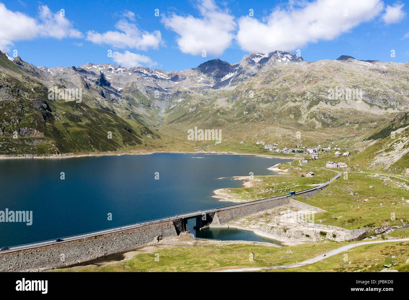 I picchi rocciosi telaio la diga che circonda il lago blu Montespluga in estate Val Chiavenna Valtellina Lombardia Italia Europa Foto Stock