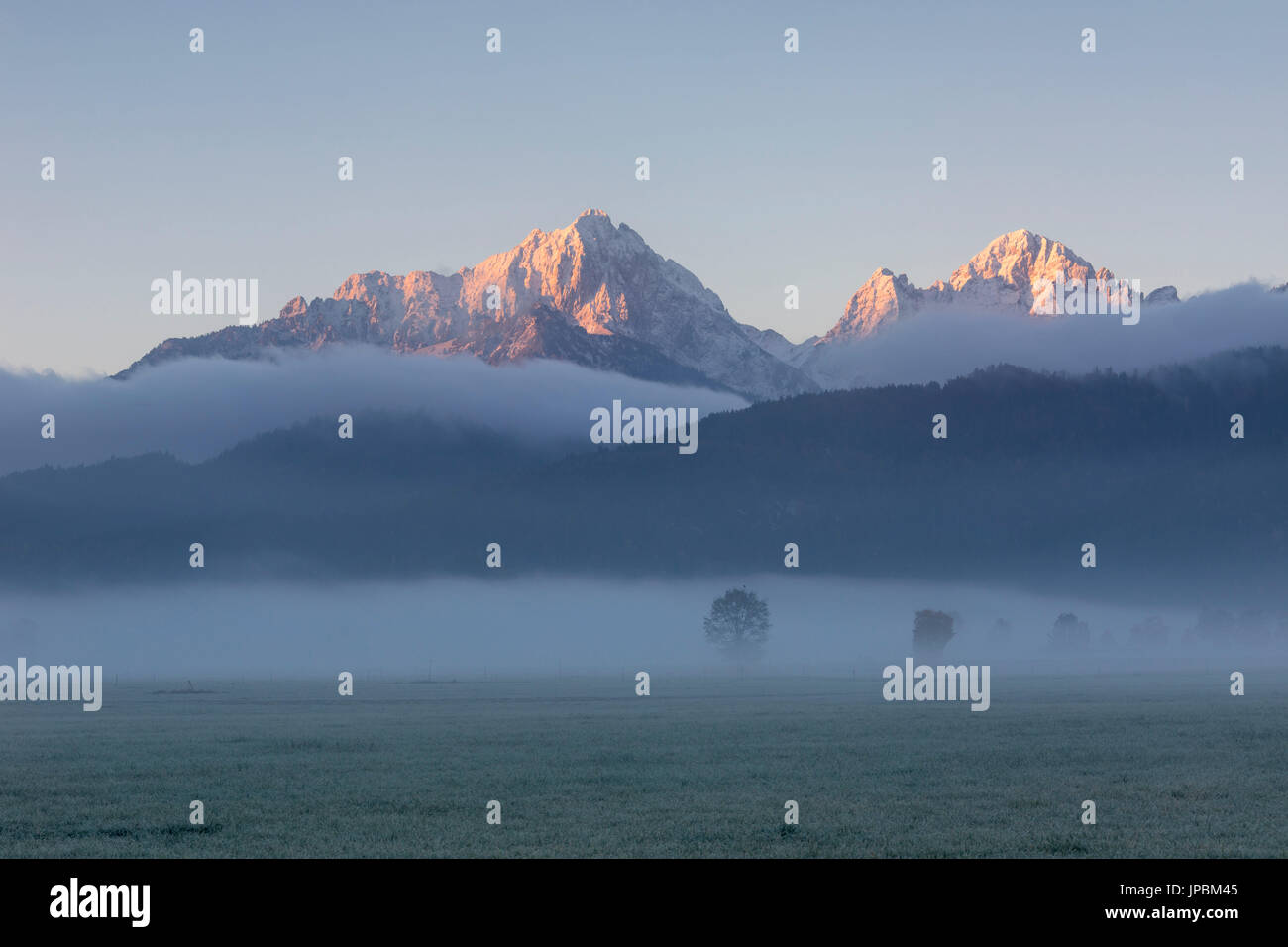 Della nebbia d'autunno a sunrise telai le cime innevate St Coloman Schwangau Baviera Germania Europa Foto Stock