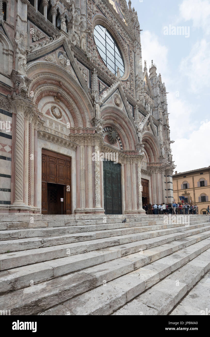 L'antica scalinata e sculture artistiche della facciata della storica cattedrale di Siena Toscana Italia Europa Foto Stock