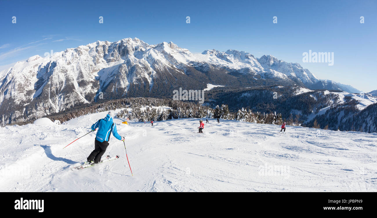 Alcuni sciatori sono lo sci lungo le piste da sci di Folgarida ski resort con Gruppo di Brenta in background. Provincia di Trento, Trentino Alto Adige, Italia, Europa Foto Stock