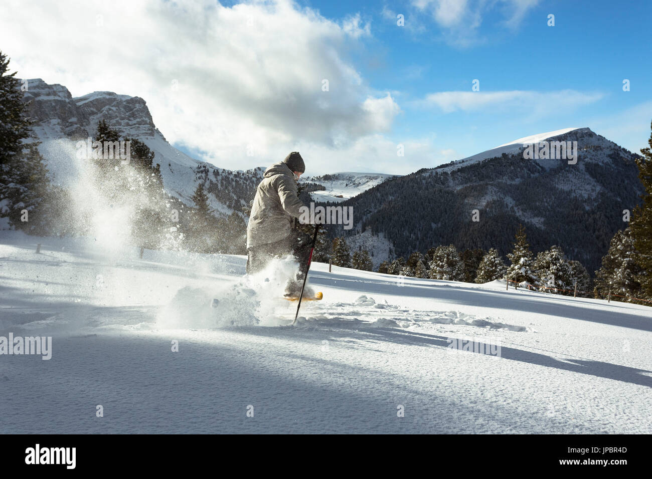 Un escursionista con le racchette da neve in esecuzione in polvere, lungo la Adolf Munkel Weg, uno dei più belli in rotta Villnössertal della provincia di Bolzano, Trentino Alto Adige, Alto Adige, Italia, Europa. Foto Stock