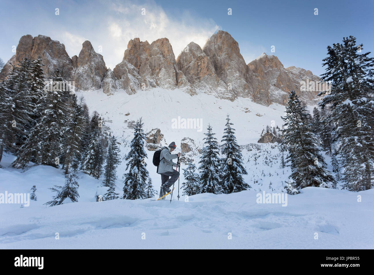Un escursionista con le racchette da neve e il Geisler in background, lungo la Adolf Munkel Weg, uno dei più belli in rotta Villnössertal della provincia di Bolzano, Trentino Alto Adige, Alto Adige, Italia, Europa. Foto Stock