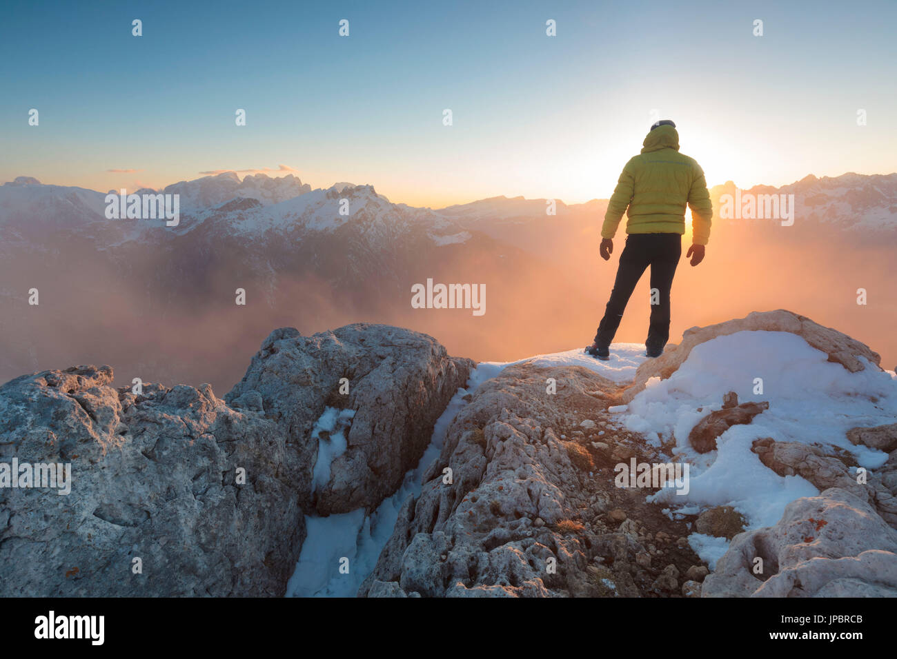 L'Europa, Italia, Veneto Belluno, Agordino, Palazza alta delle Dolomiti. Escursionista in cima a una montagna ammirando il tramonto Foto Stock