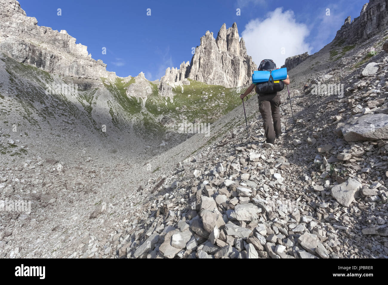 Escursionista a risalire la valle verso il Monfalcon Forni e la forcella dello stesso nome. Dolomiti Friulane e Oltrepiave, Pordenone Foto Stock