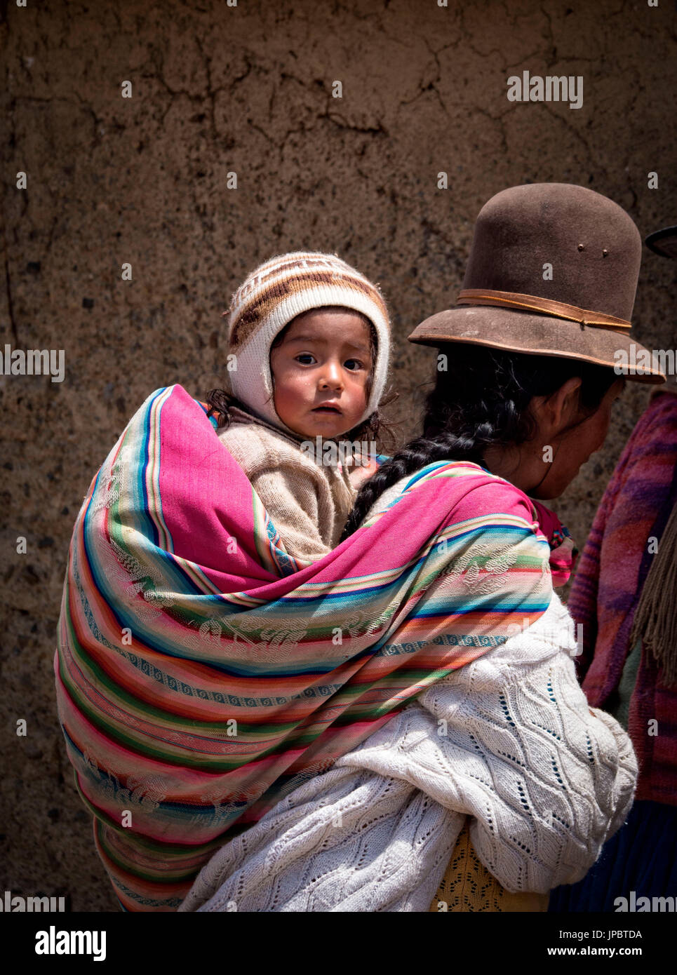 L Aymara il bambino e sua madre vestita con il costume tipico. Aymaras sono la popolazione autoctona del Lago Titicaca area, in Bolivia, Sud America. Foto Stock