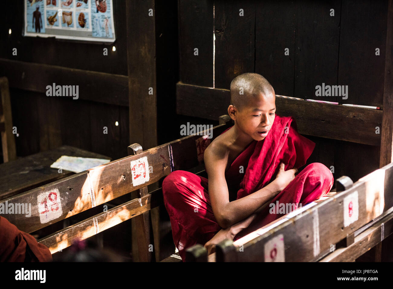 Inwa, Mandalay regione, Myanmar (Birmania). Un giovane monaco studiare in Bagaya Kyaung monastero. Foto Stock