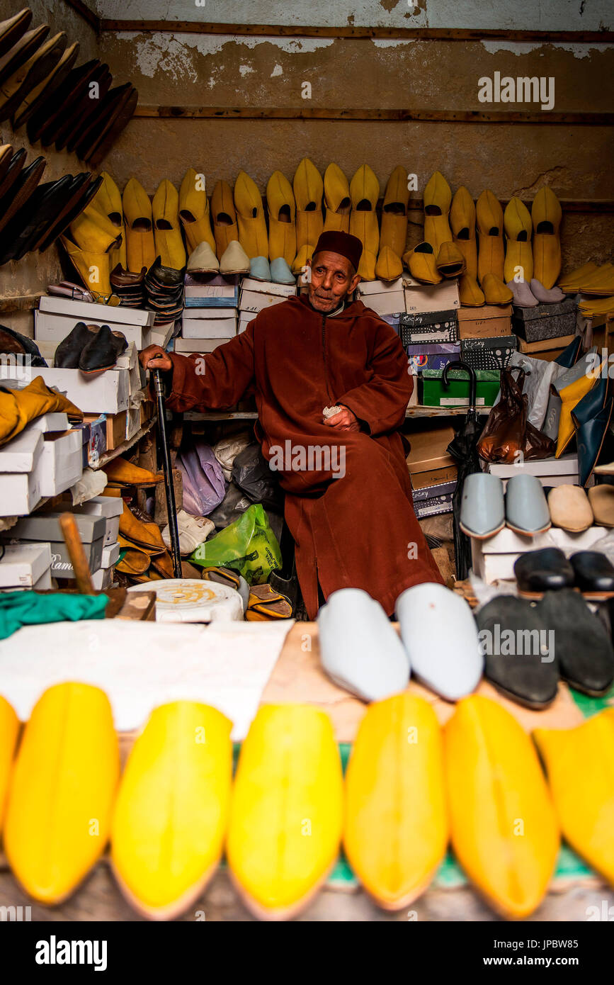 La Fes, Marocco, Africa del Nord. Un vecchio uomo seduto nel suo piccolo negozio di scarpe. Foto Stock