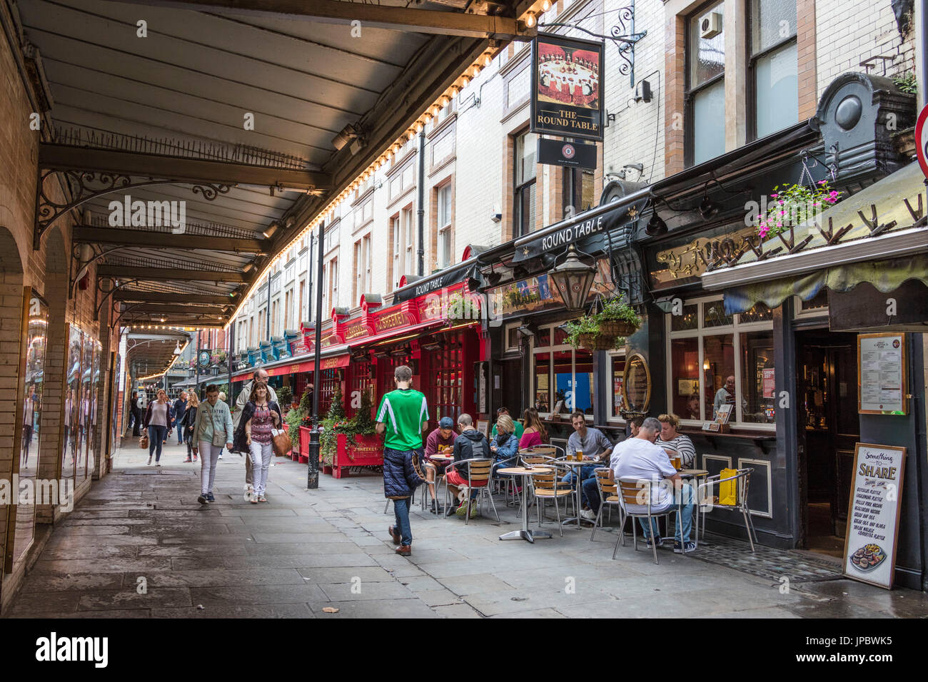 La gente a piedi nella zona pedonale con bar e ristoranti di Leicester Square Covent Garden Camden London Regno Unito Foto Stock