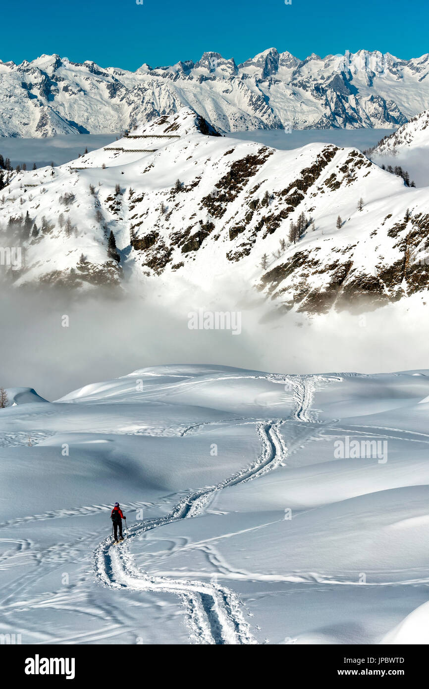 Escursionista Trekking attraverso la fitta neve in Val Gerola Alpi, Lombardia, Italia Foto Stock