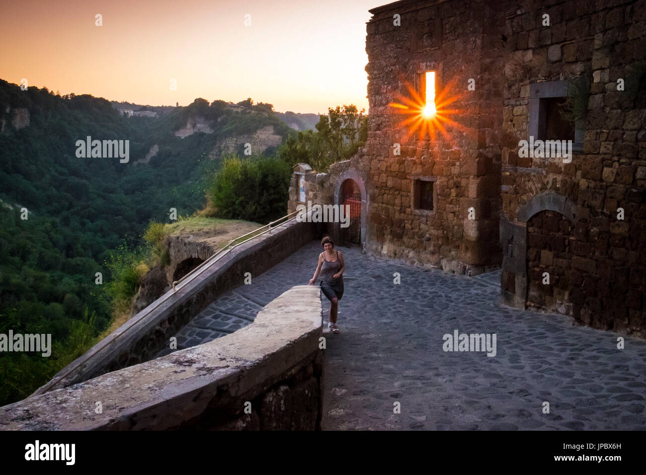 Civita di Bagnoregio, Viterbo, Lazio, Italia Centrale, Europa. La donna a piedi dall'entrata della città vecchia. Foto Stock