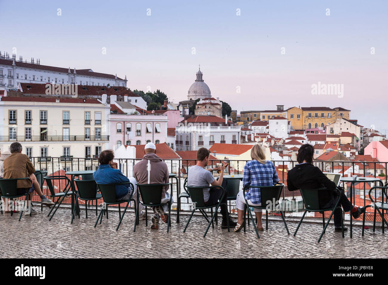 Ai turisti di ammirare i tetti di terracotta e antico Duomo da una terrazza a Miradouro Alfama punto di vista di Lisbona Portogallo Europa Foto Stock