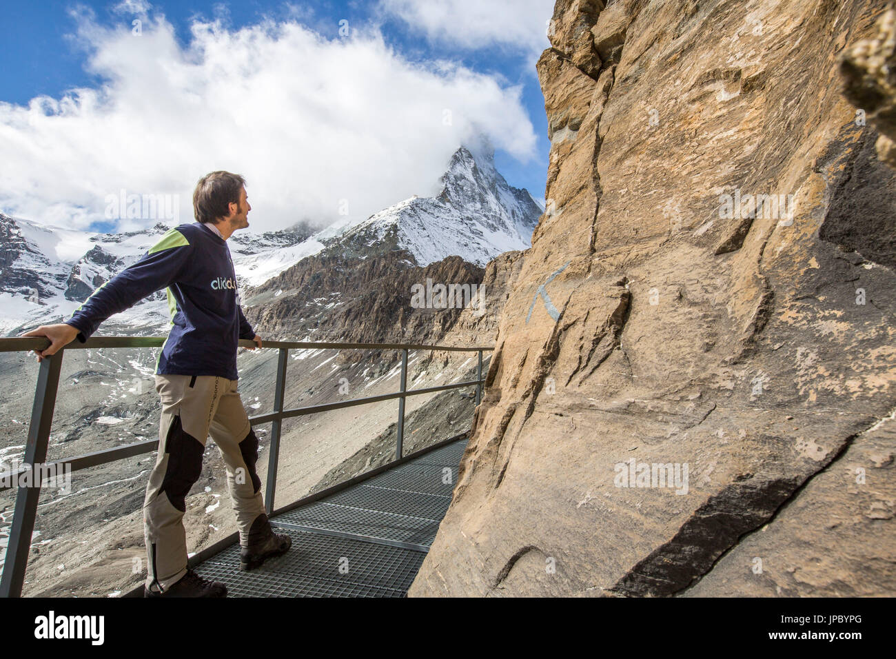 Escursionista guardando il Cervino, che è quasi tutto coperto di nebbia, da la via che porta al Hornli-hutte. Zermatt, Vallese, Svizzera. Foto Stock