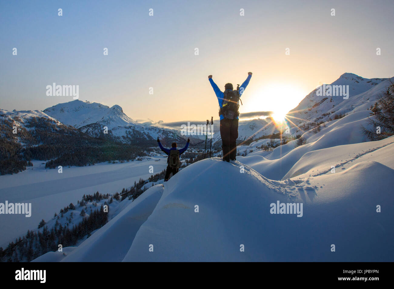 Gli escursionisti con racchette da neve gioire retroilluminata con vista sul lago di Sils. Maloja Pass. Engadina. La Svizzera. Europa Foto Stock