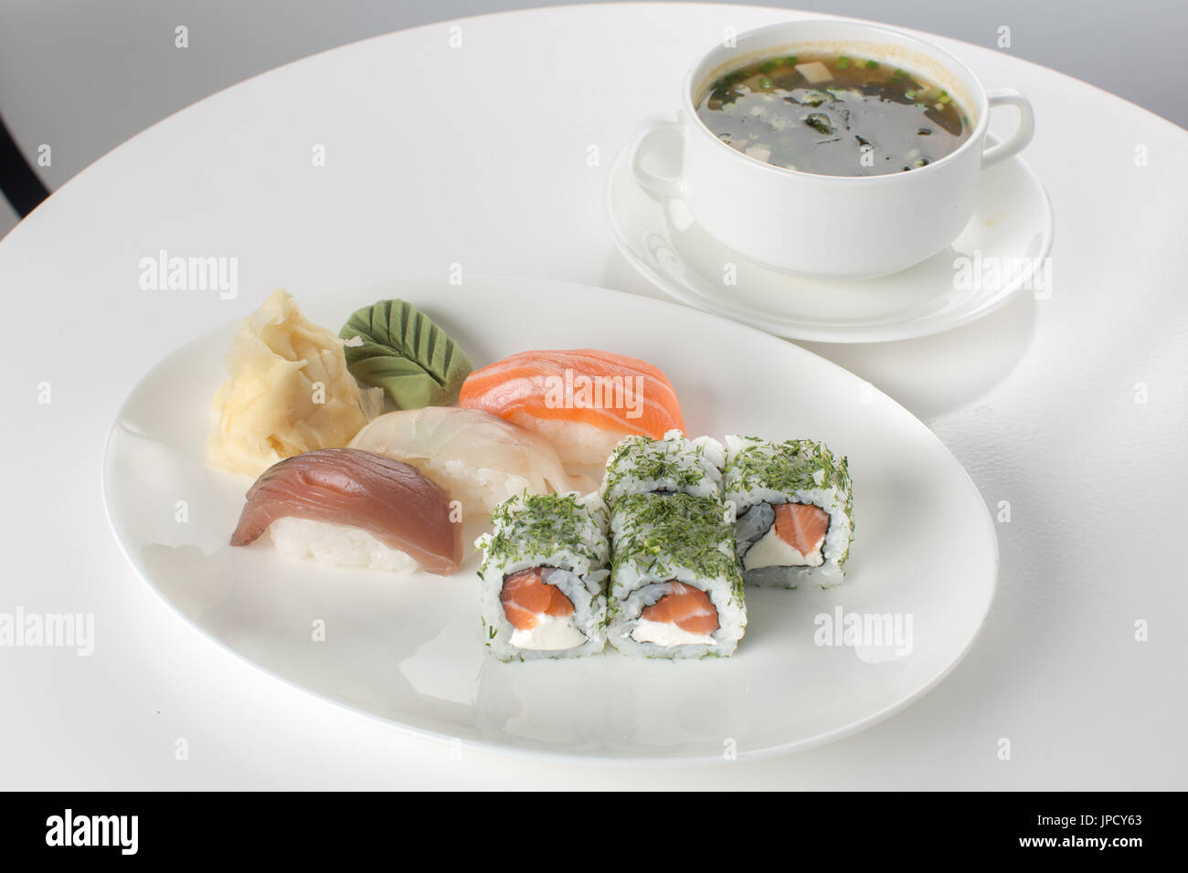 Il sushi e la minestra sul tavolo bianco Foto Stock