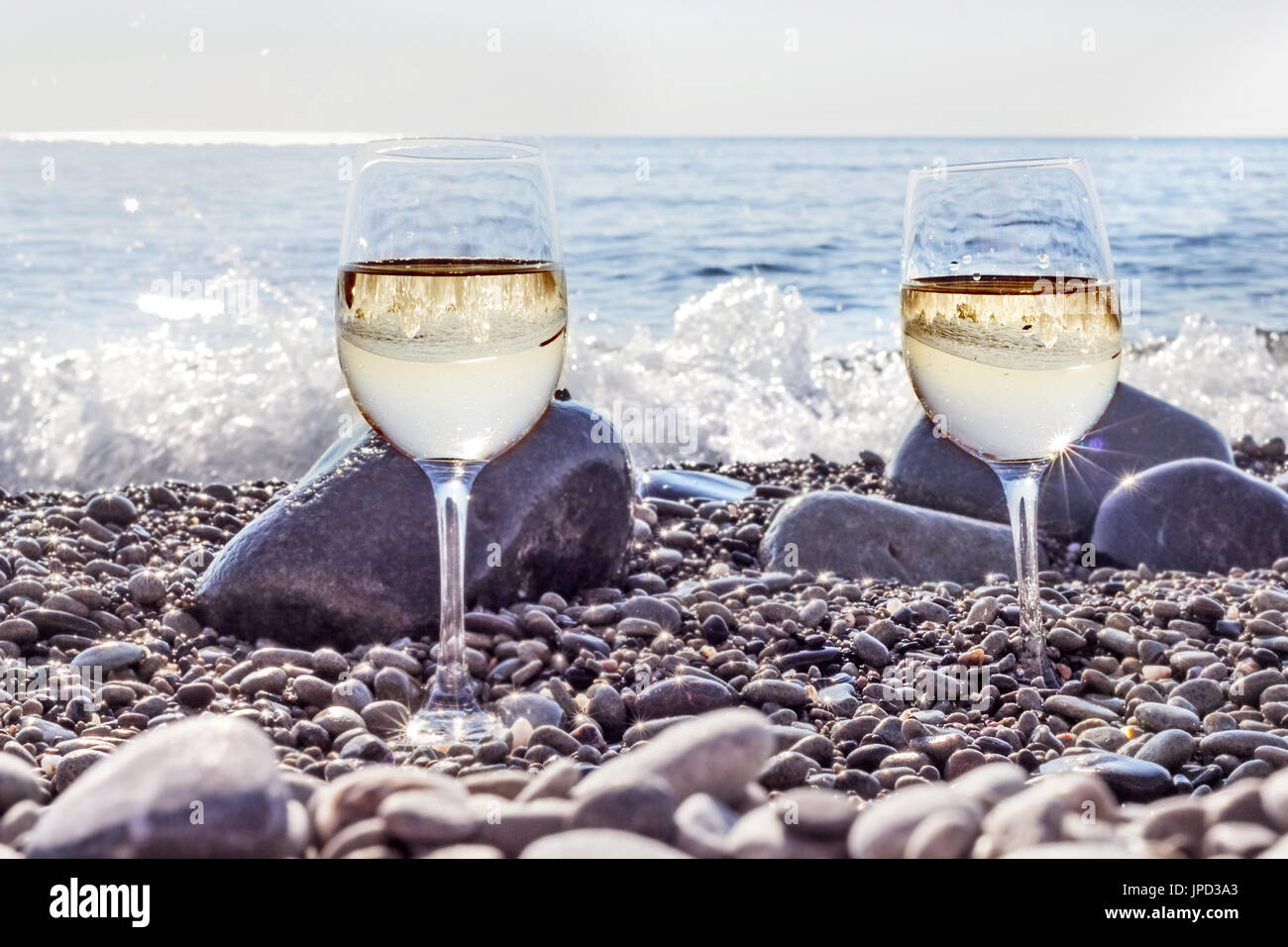 Due bicchieri di vino bianco sulla spiaggia vicino oceano al mattina felice Foto Stock
