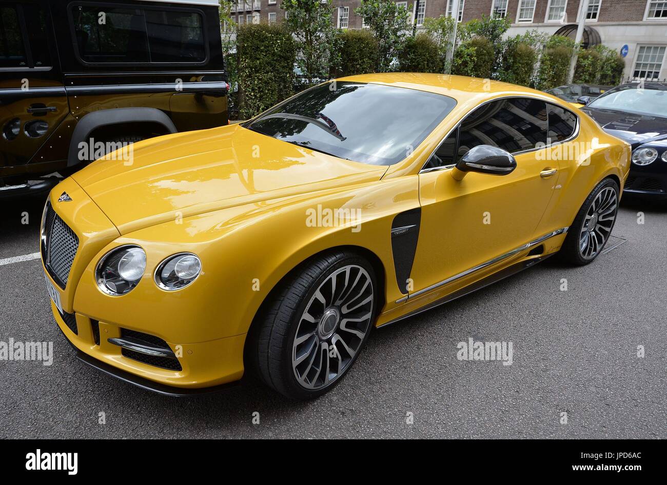 Un giallo Bentley personalizzata con numero di Dubai piastre al di fuori il Park Tower Knightsbridge Hotel in Londra, agosto vede centinaia di medio orientali battenti-in e guidando in supercar. Foto Stock