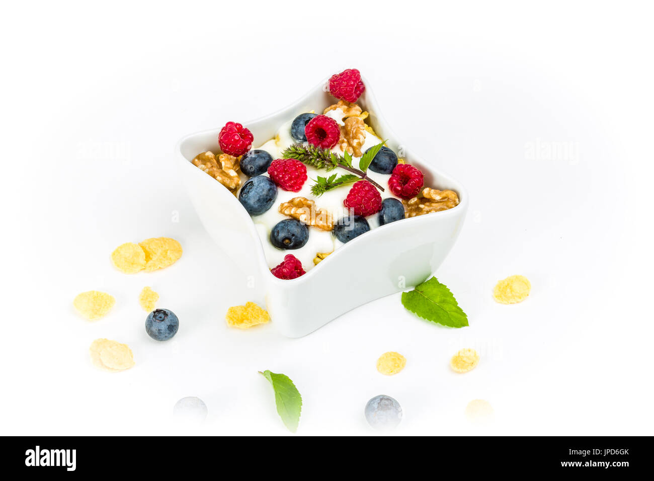 Fiocchi di mais con yogurt, miele, noci lamponi e mirtilli. concetto di alimenti sani. Foto Stock