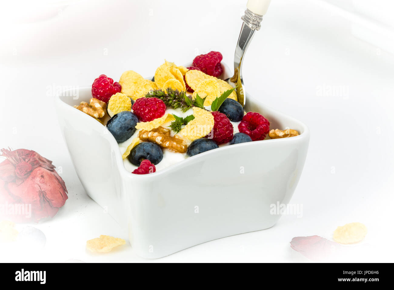 Fiocchi di mais con yogurt, miele, noci lamponi e mirtilli. concetto di alimenti sani. Foto Stock