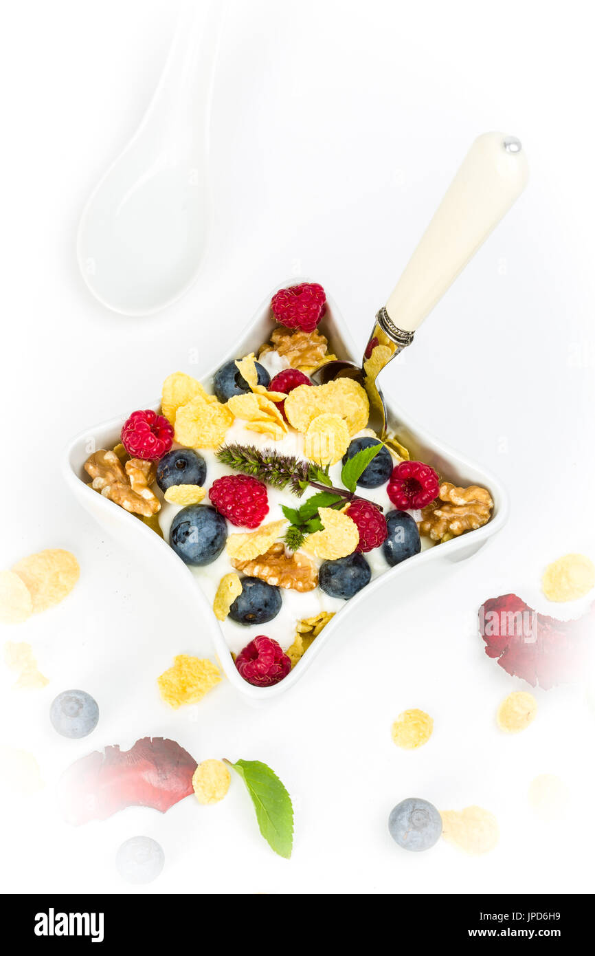 Fiocchi di mais con yogurt, miele, noci lamponi e mirtilli. concetto di alimenti sani. Foto Stock