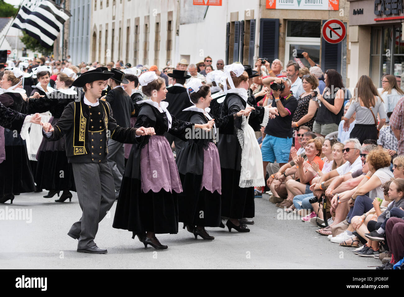 Brittany - persone in abito tradizionale danza per strada a Fete des Brodeuses, Pont L'Abbe, Bigouden, Finisterre, Bretagna Francia Europa Foto Stock
