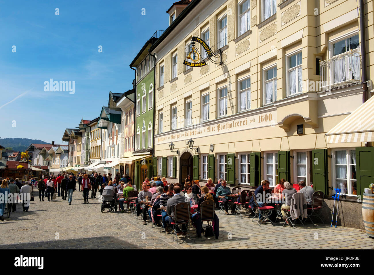 La gente seduta in taverna nella parte anteriore della fila di case storiche, Marktstraße, Bad Tolz, Alta Baviera, Baviera, Germania Foto Stock