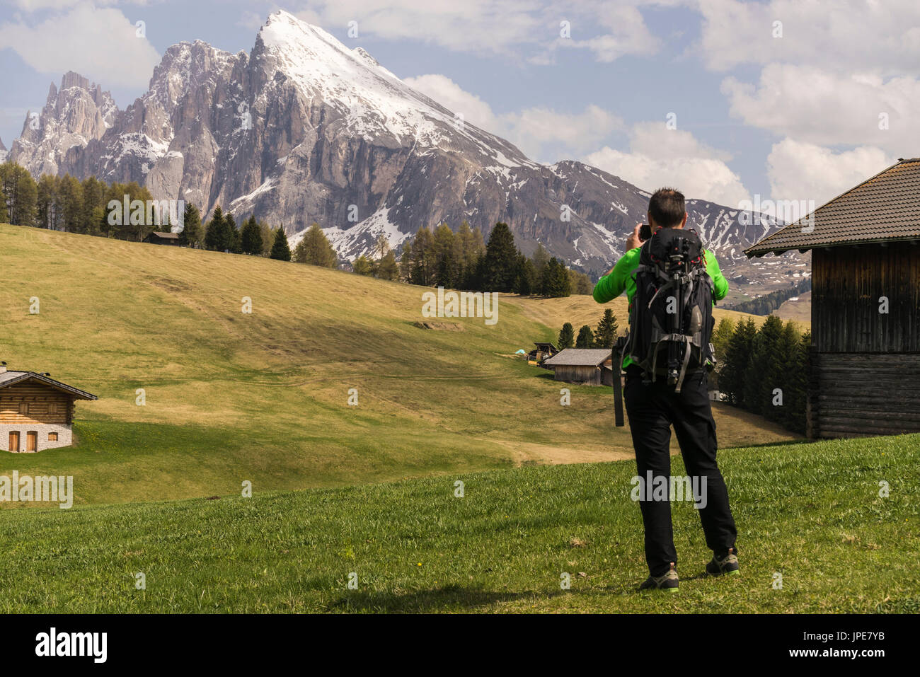 Alpe di Siusi / Seiser Alm, Dolomiti, Alto Adige, Italia. Escursionista scattare una foto con il Sassolungo/Sassolungo e Sassopiatto in background Foto Stock