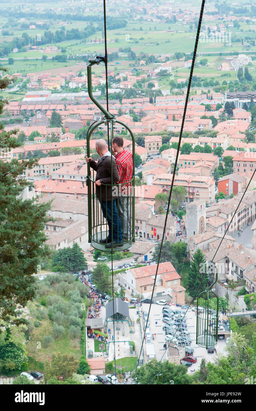 Europa,l'Italia,Umbria, Gubbio. Due persone in una macchina di cavo con la città di Gubbio in background Foto Stock