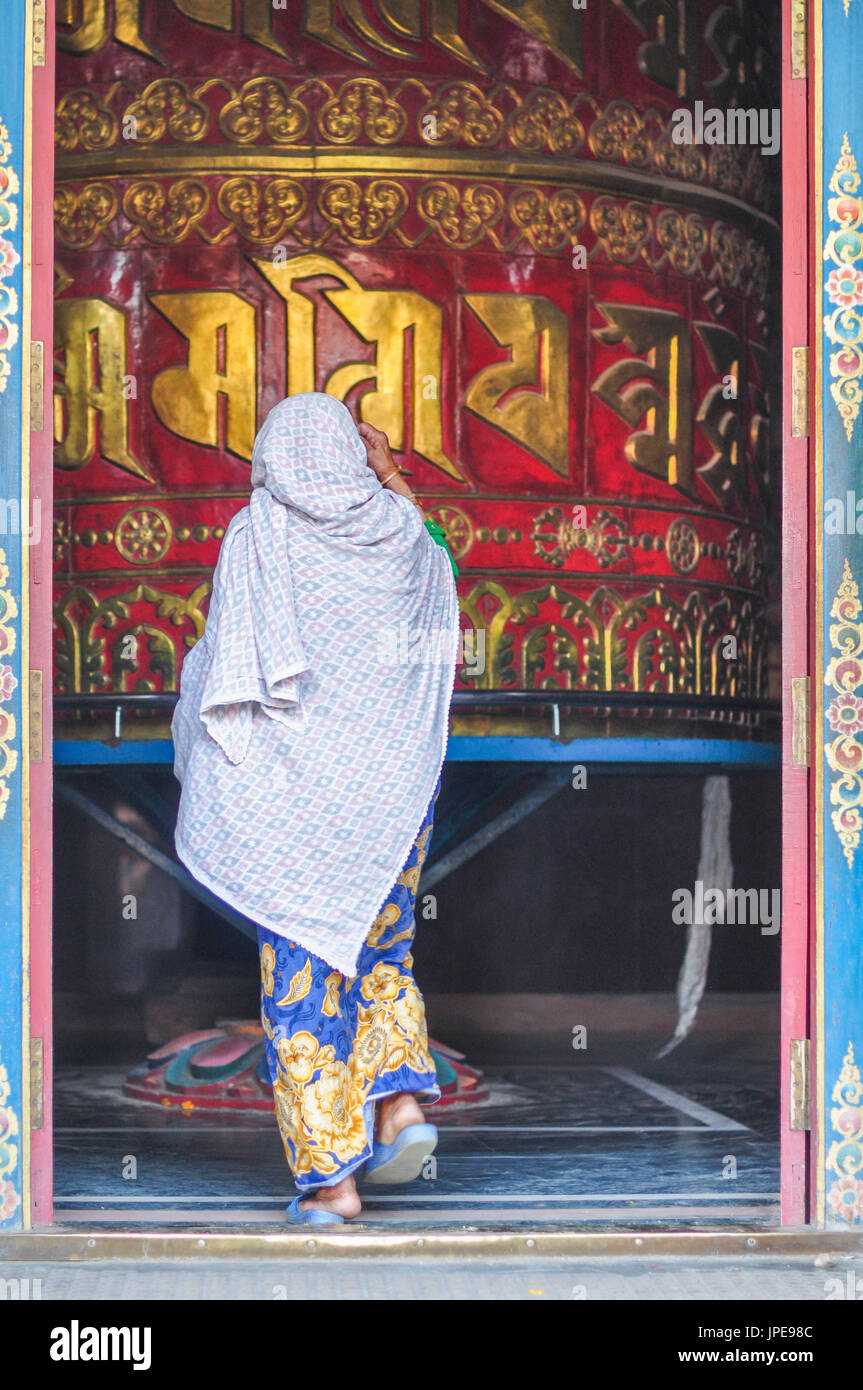 Donna locale sta andando attorno ad una ruota di preghiera,Swayambhunath ,Valle di Kathmandu, Nepal,Asia Foto Stock