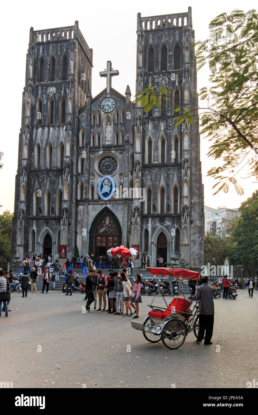 Turisti e popolazione locale a piedi nella parte anteriore del Saint Joseph cattedrale, la più importante chiesa di Hanoi Foto Stock