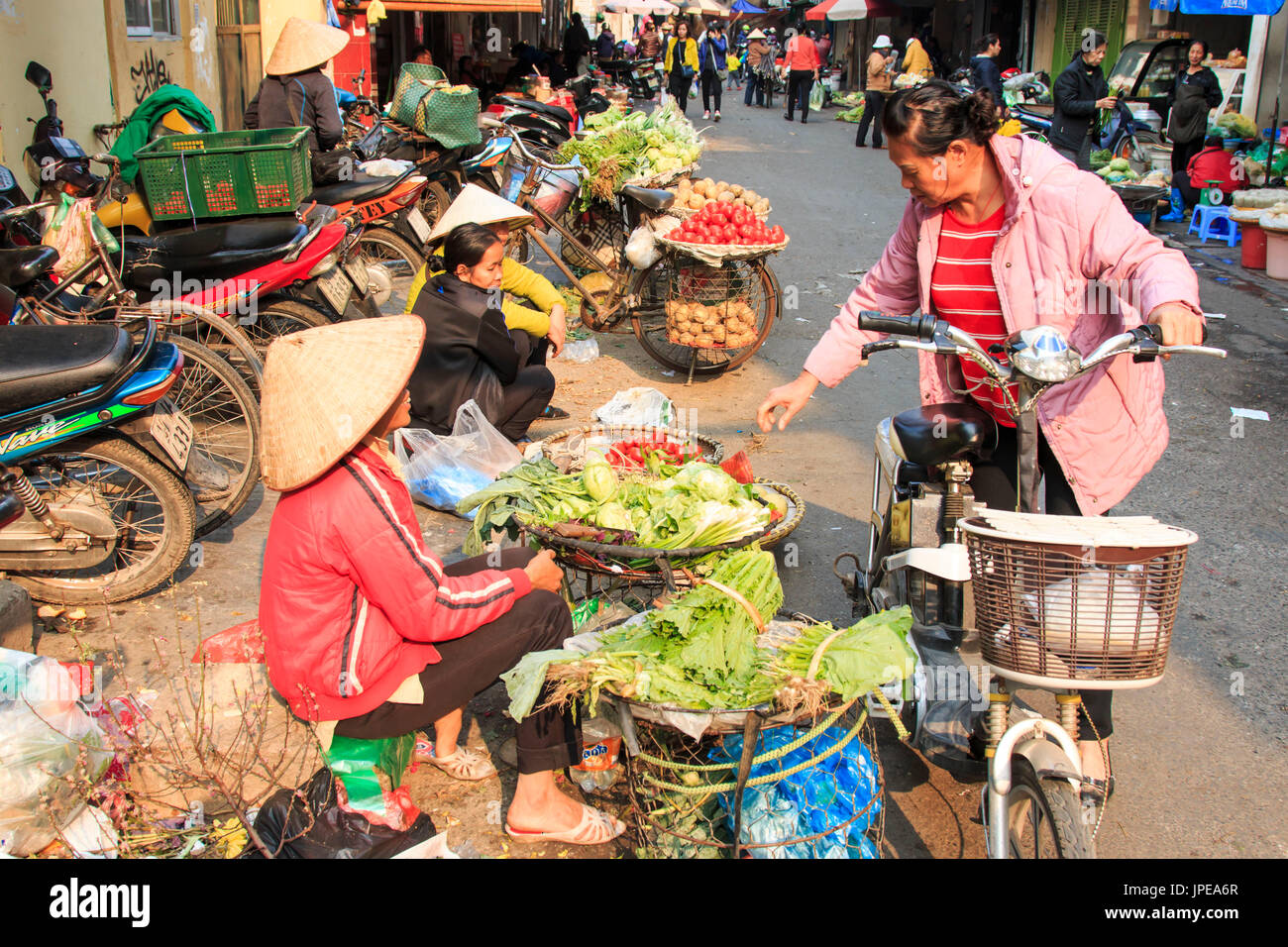 Womand la vendita di frutta e verdura in un mercato di strada di Hoàn Ki?m, il quartiere vecchio di Hanoi Foto Stock