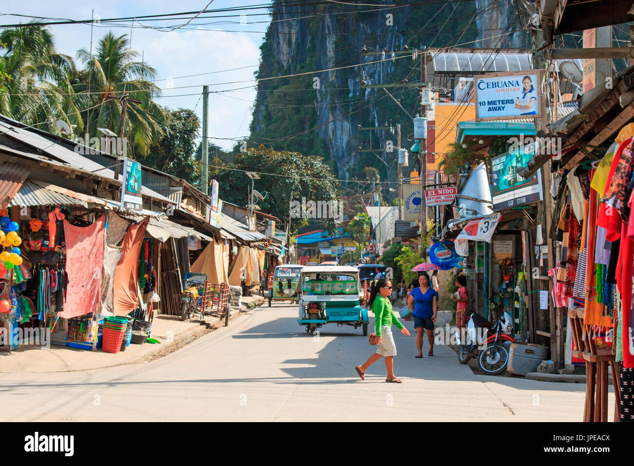 El Nido, PALAWAN FILIPPINE. La strada principale di El Nido di Palawan, una delle principali isole delle Filippine. Tricicli e persone locali sul primo piano. Foto Stock
