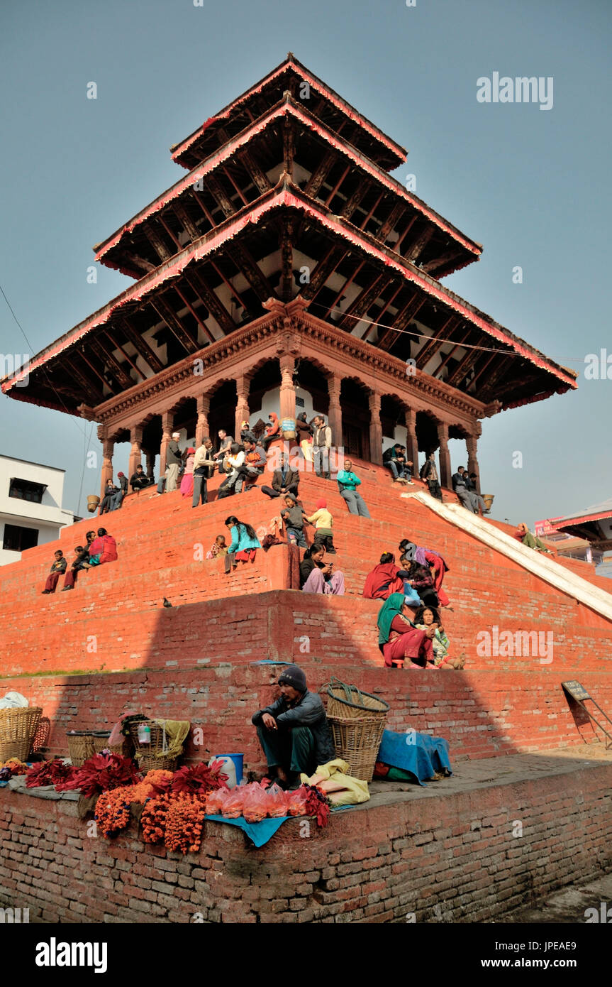 Tempio di il quadrato di Durbar Square, dove le popolazioni locali sono di relax al sole o vendere beni per i passanti. Khatmandu, Nepal. Foto Stock