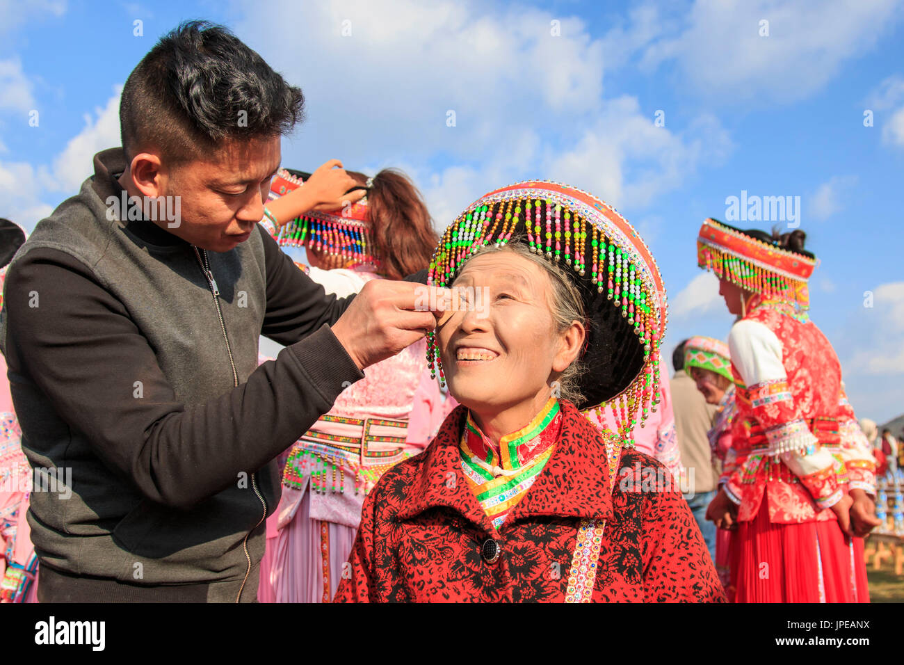 Donna cinese nei tradizionali costumi Miao durante il Heqing Qifeng Pera festival dei fiori, Cina Foto Stock
