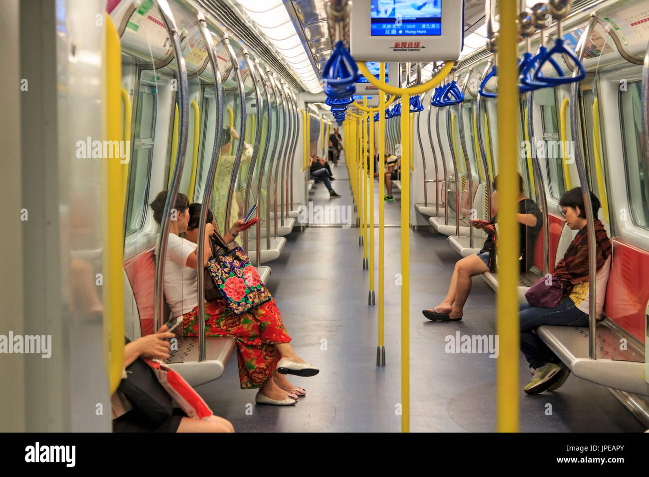 Pendolari all'interno di un treno della MTR di Hong Kong, il più popolare mezzo di trasporto in città, Cina Foto Stock
