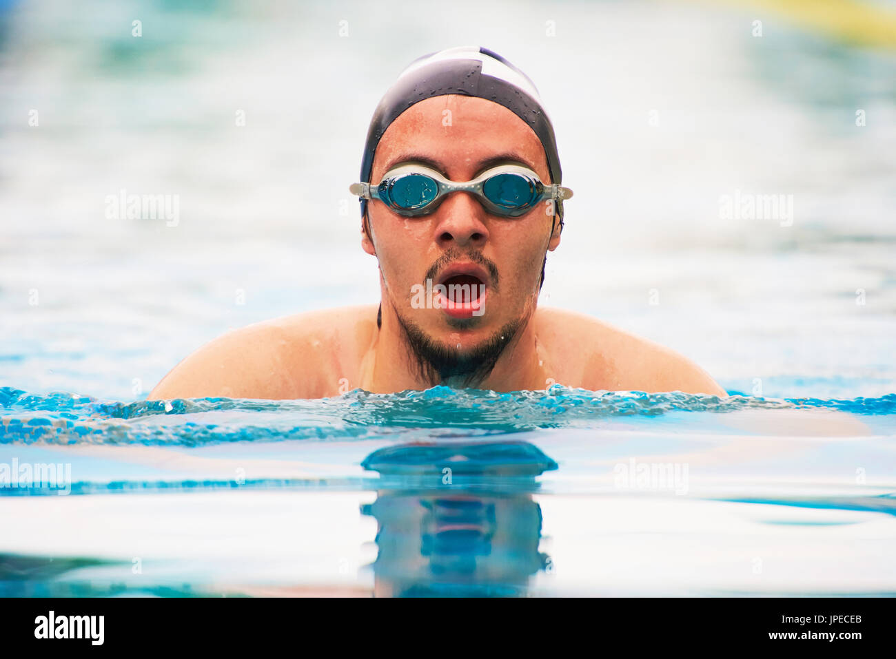 Ritratto di triatleta uomo nuoto in piscina. Giovane maschio nuotatore Foto Stock