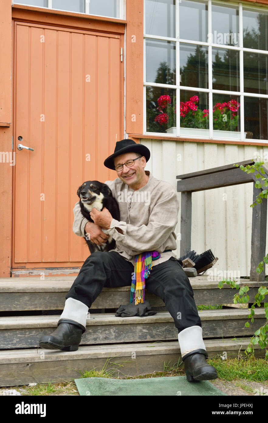 Contadino con il suo cane preferito sul portico di casa sua. La Lapponia finlandese Foto Stock