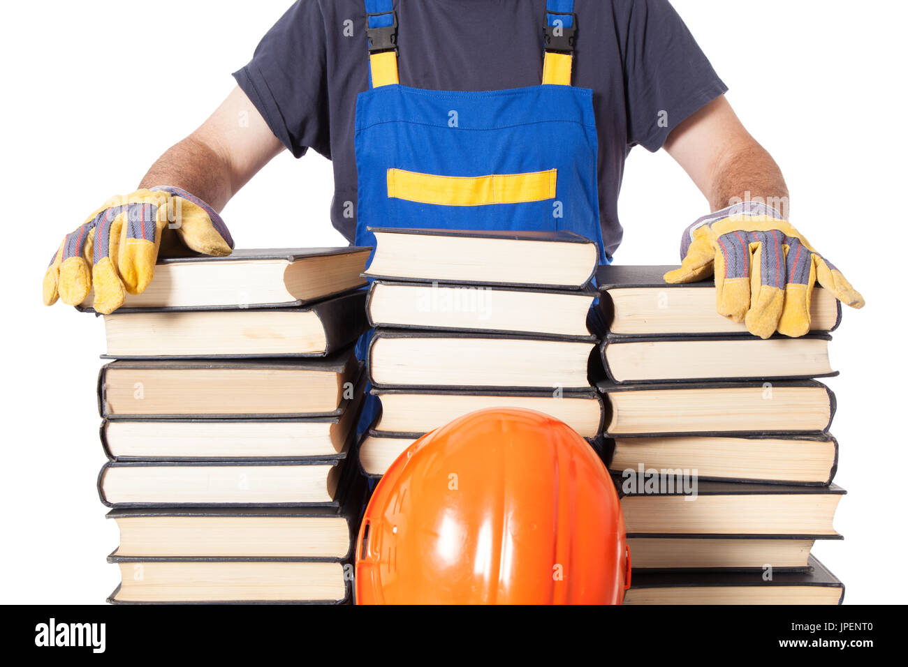 Lavoratore in abiti da lavoro e i guanti con le mani su una pila di molti libri isolati su sfondo bianco Foto Stock