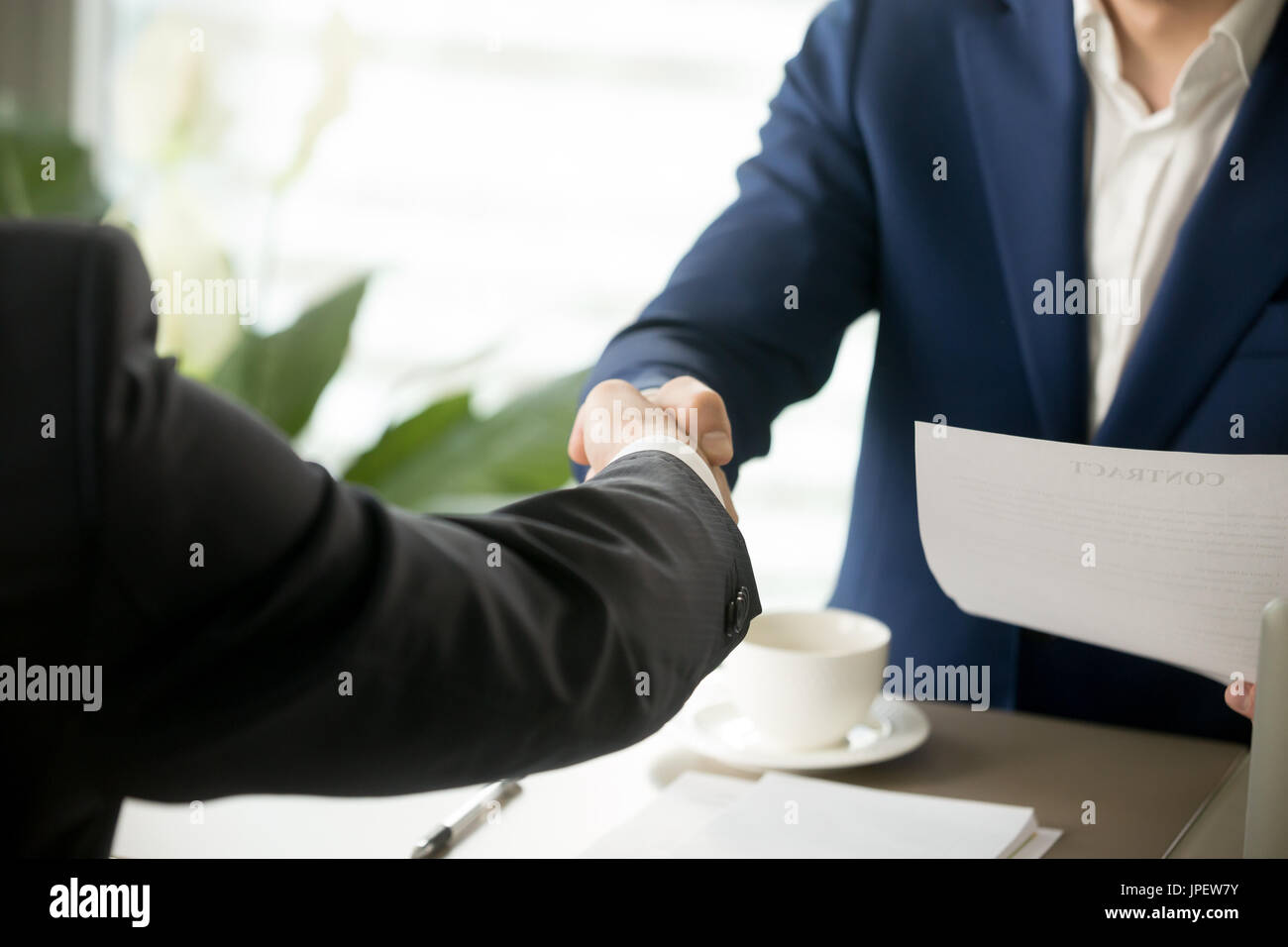 Close up di business handshake, maschio agitando le mani dopo la firma Foto Stock